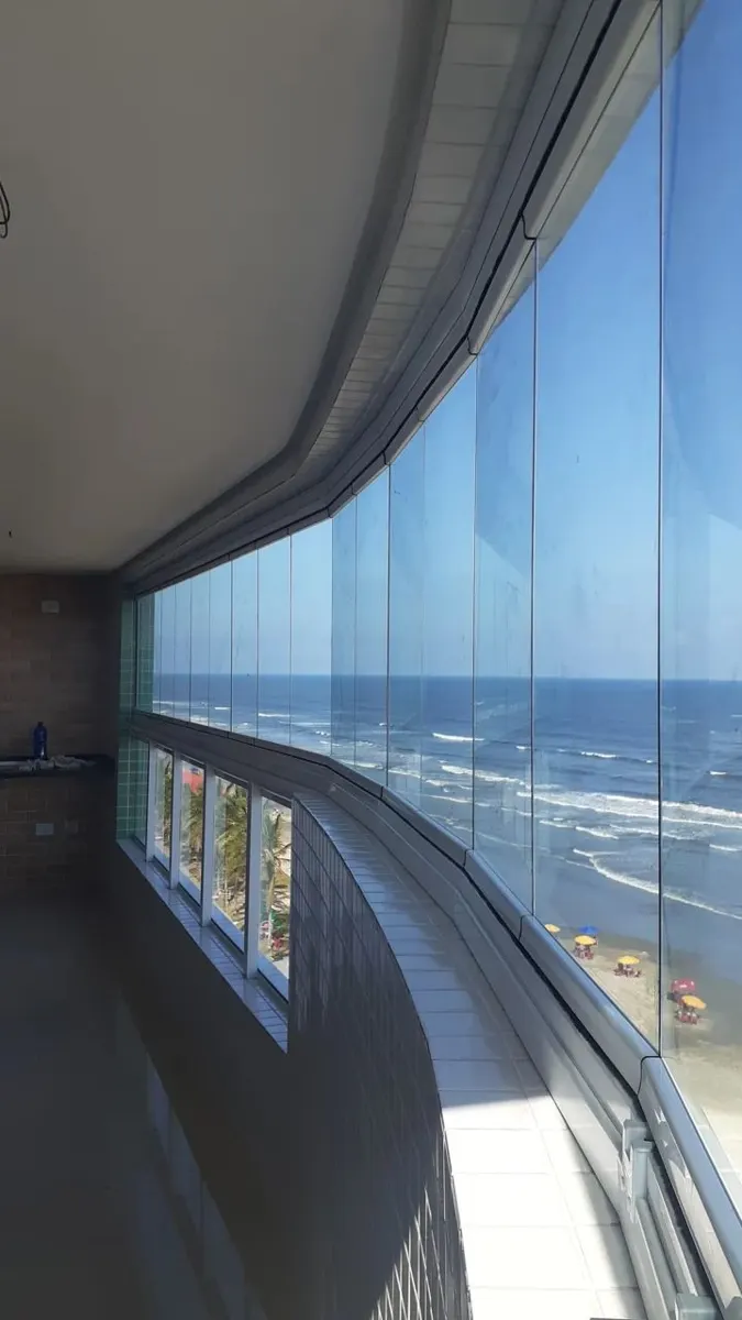 Sacada com cortina de vidro e vista para o mar no litoral sul de SP